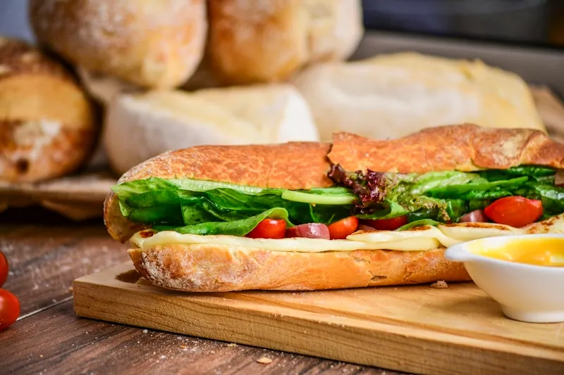 Fresh deli baguette roll with greens and tomato